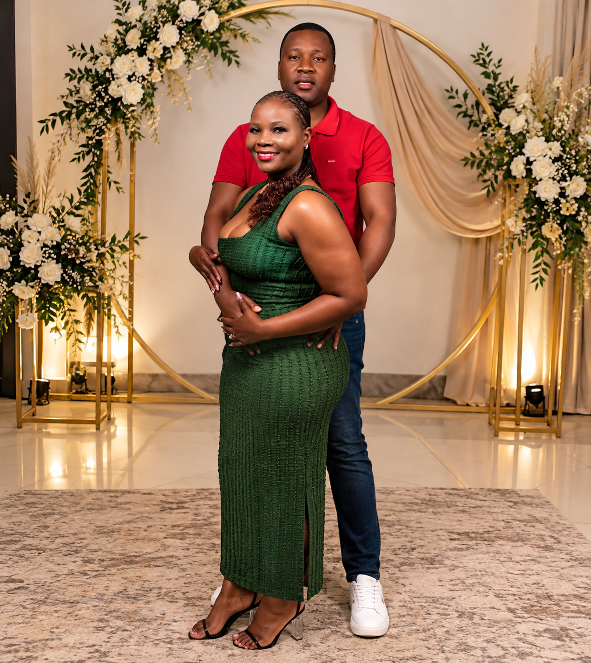 Zakhele and Nelisiwe beneath a floral golden arch